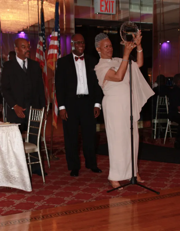 A woman in white dress holding up a microphone.