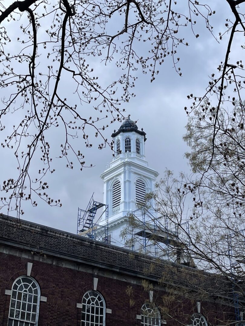 A clock tower with a white bell on top of it.