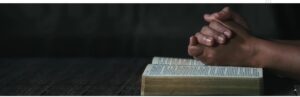 A person is reading the bible on a table